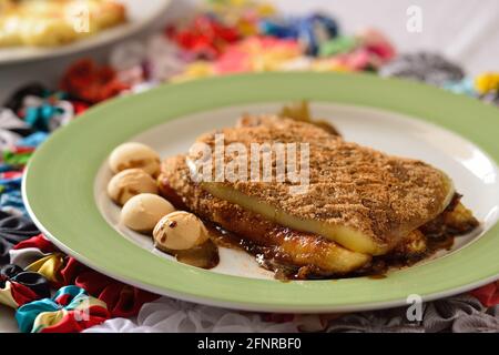 Typisches brasilianisches Dessert, bekannt als Cartola oder Zylinderhut Dessert, hergestellt mit gebratenen Kochbananen, Käse, Zucker und pulverförmiger Schokolade. Stockfoto