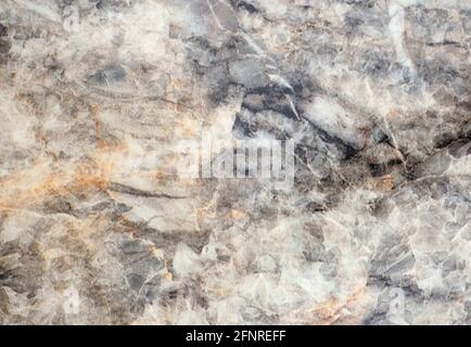 Grauer Achat, polierte flache Oberfläche aus Naturstein mit schwarzen und gelben Adern und Flecken. Hintergrund, Muster, Textur. Stockfoto