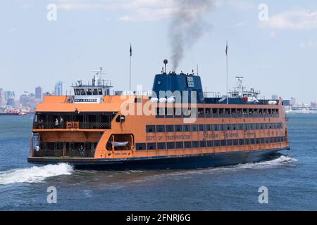 Orange Staten Island Ferry Boat, eine Passagierfähre, mit Skyline von Downtown Manhattan New York während des Tages Stockfoto