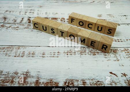 Kundenfokus Buchstaben in Wort auf hölzernem Hintergrund Stockfoto
