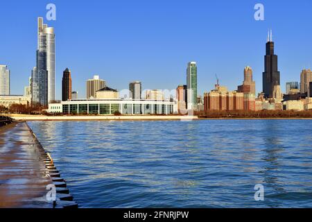 Die Morgensonne über dem Lake Michigan spiegelt sich vom Adler Planetarium und einem Teil der Skyline von South Loop in Chicago wider. Stockfoto