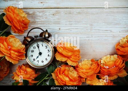 Vintage Wecker und Blumenstrauß mit Weltraumkopie auf Holzhintergrund Stockfoto