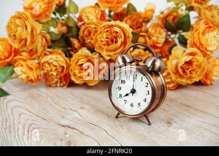 Vintage Wecker und Blumenstrauß mit Weltraumkopie auf Holzhintergrund Stockfoto