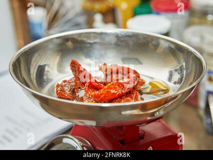 Sonnengetrocknete Tomaten auf Waage, bereit für die Herstellung von sonnengetrockneten Tomatenmuffins. Stockfoto