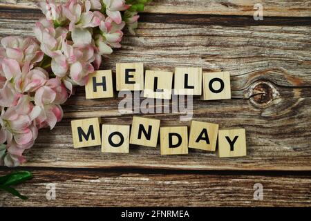 Hallo Montag Alphabet Buchstabe mit blühender Blume auf hölzernem Hintergrund Stockfoto