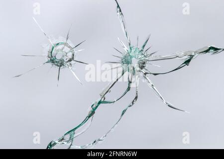 Einschusslöcher im Glas, gebrochenes Glas, die Wirkung des Brechens, Textur für das Design Stockfoto