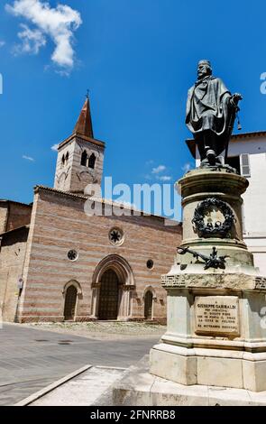 Foligno Piazza Garibaldi , Kirche von San Salvatore Fassade mit Reihen von roten und weißen Steinen , im Vordergrund Garibaldi Bronzefigur von Ottaviani Stockfoto