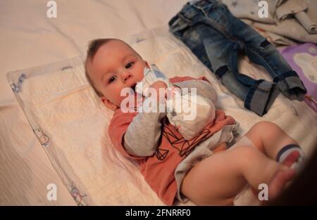 Mutter, die Windeln von niedlichen kleinen Jungen wechselt Stockfoto