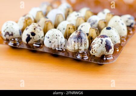 Wachteleier in Verpackung auf einem Holztisch Stockfoto