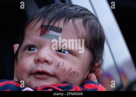 Columbus, Usa. Mai 2021. Frau hält ein Baby mit einer palästinensischen Fahne auf seiner Stirn und dem Wort Palästina auf seiner Wange während der Demonstration. Demonstranten versammelten sich im Staatenhaus von Ohio, um gegen die israelische Besetzung Palästinas zu protestieren. Kredit: SOPA Images Limited/Alamy Live Nachrichten Stockfoto