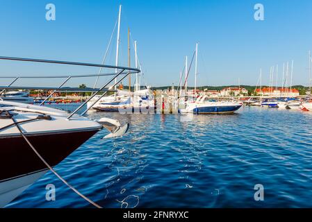 Segelyachten liegen an einem sonnigen Morgen an einem Pier in einem Hafen an der ostsee. Nautisches Schiff für Charter Stockfoto