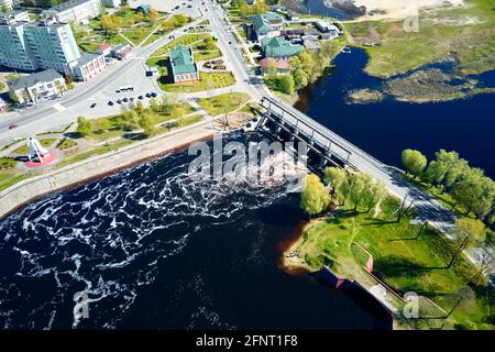 Luftaufnahme der Stadt Dobrush, Region Gomel. Blick auf die Stadt mit einer Brücke über den Fluss und einem Damm, Vogelperspektive Stockfoto