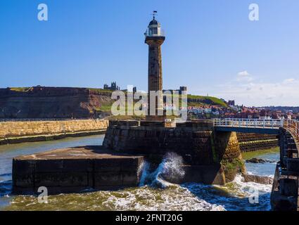 Whitby Leuchtturm mit den Abteiruinen und der Kirche St. Mary im Hintergrund. Stockfoto