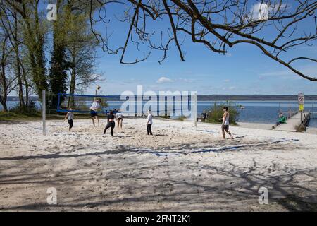Eine Gruppe junger Leute, die Beachvolleyball am Ufer des Ammersees, Ammersee, Oberbayern, Deutschland, Europa spielen. Stockfoto