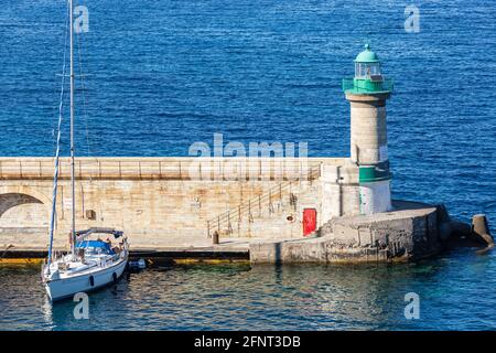 Grüner Leuchtturm am Ende der Anlegestelle, der den Eingang zum Hafen von Bastia auf Korsika markiert Stockfoto