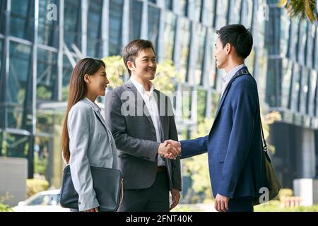 asiatische Geschäftspartner treffen sich auf der Straße in der Innenstadt von Financial Bezirk schüttelt die Hände Stockfoto