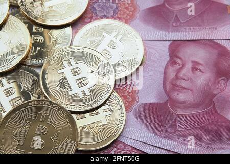 Bitcoin in China Konzept. Bitcoin-Münzen auf Yuan-Banknoten platziert. Verbot von Bitcoin in der Republik China. Stockfoto