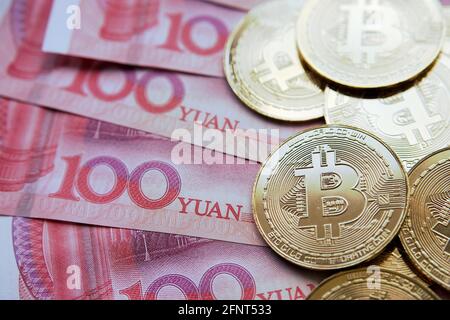 Bitcoin in China Konzept. Bitcoin-Münzen auf Yuan-Banknoten platziert. Verbot von Bitcoin in der Republik China. Stockfoto