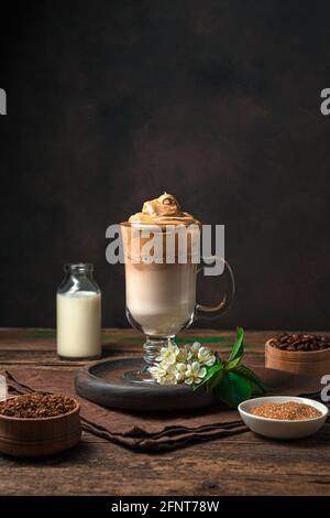 Kaffee-Dessert mit Milch und Eis auf braunem Hintergrund. Koreanischer Dalgona-Kaffee. Stockfoto