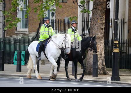 Zwei Polizisten in fluoreszierenden Uniformen auf Pferden patrouillieren Whitehall, Westminster, London, Großbritannien Stockfoto