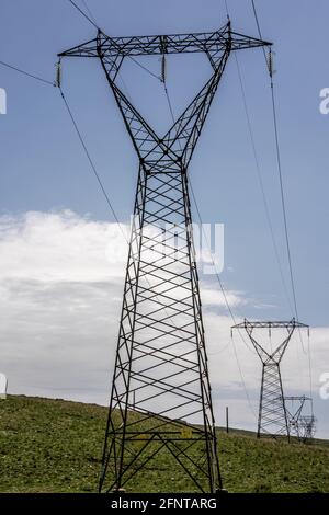 Hochspannungsmasten auf einem kargen Hügel. Abruzzen, Italien, Europa Stockfoto