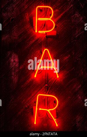 Leuchtendes Neon-rotes Schild AUF Holzhintergrund. Dunkles Vintage-Bild. Stockfoto