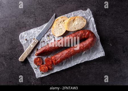 Spanische Chorizo-Wurst und Brot auf schwarzem Schieferhintergrund Stockfoto