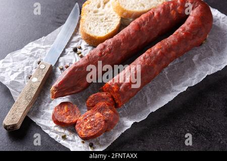 Spanische Chorizo-Wurst und Brot auf schwarzem Schieferhintergrund Stockfoto