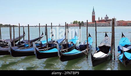 Gondeln typisch venezianische Boote, die im Kanal von Giudecca festgemacht sind Vorderseite der alten Kirche von San Giorgio Stockfoto