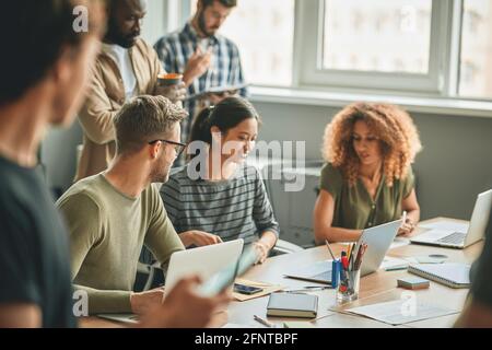 Junge Kollegen arbeiten an einigen Arbeitsaufgaben zusammen Stockfoto