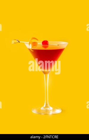 Traditioneller Manhattan Cocktail mit Kirsche auf gelbem Hintergrund Stockfoto