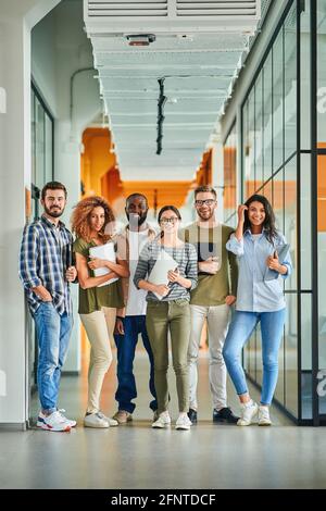 Sechs junge Menschen lächeln und posieren mit Laptops in den Händen Stockfoto