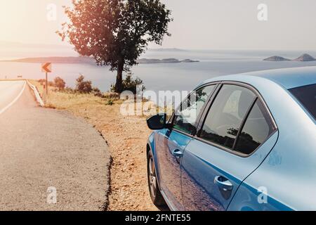 Blaues Auto hielt am Straßenrand in der Nähe des Meeres an sonnigen Tag Stockfoto
