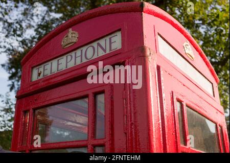 Oberer Teil einer traditionellen roten Telefonbox in einem sonnigen Park in Kent, Großbritannien Stockfoto