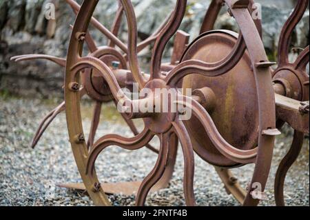 Metallrad auf einer antiken landwirtschaftlichen Ausrüstung Stockfoto