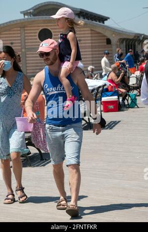 Ein Vater trägt seine Tochter auf seinen Schultern in Coney Island, Brooklyn, New York. Stockfoto