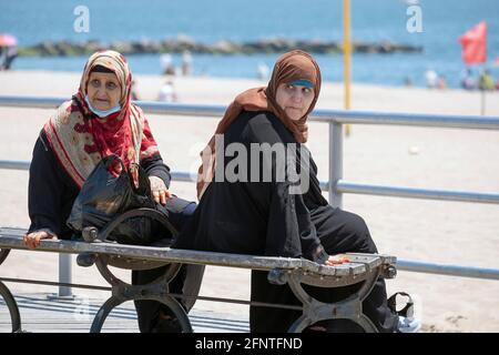 Schlepptau Ältere muslimische Frauen in Hijabs schlagen ähnliche Posen auf der Promenade in Coney Island, Brooklyn, New York City. Stockfoto