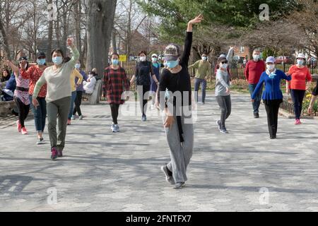 Ein schlanker anmutiger chinesisch-amerikanischer Lehrer unterrichtet in einem Park in Queens, New York City, eine Tanzübung. Stockfoto