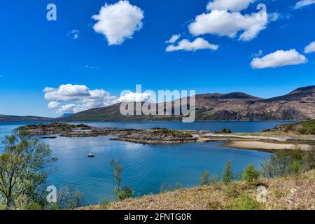 SANDAIG BAY ISLANDS AND BEACHES GLENELG SCOTLAND BLICK ÜBER DIE BUCHT IM FRÜHJAHR UND EIN KLEINES FISCHERBOOT Stockfoto