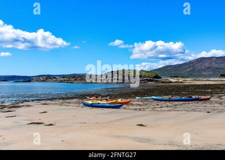 SANDAIG BAY ISLANDS AND BEACHES GLENELG SCOTLAND BLICK ÜBER DIE BUCHT IM FRÜHLING FARBENFROHE KANUS AM SANDSTRAND Stockfoto