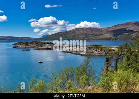 SANDAIG BAY ISLANDS AND BEACHES GLENELG SCOTLAND BLICK ÜBER DIE BUCHT IM FRÜHLING UND EIN KLEINES FISCHERBOOT Stockfoto