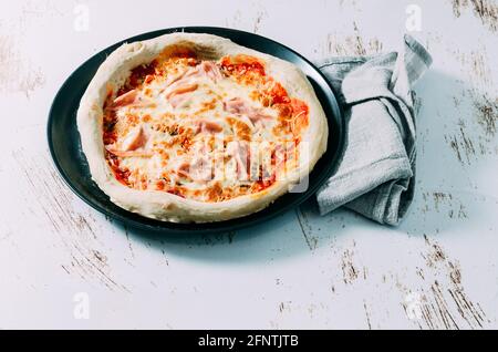 Frisch zubereitete hausgemachte Schinken- und Käsepizza. Italienisches Essen Stockfoto