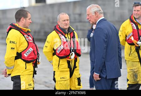 Der Prinz von Wales spricht mit Mitgliedern der Royal National Lifeboat Institution während eines Besuchs im Hafen von Donaghadee. Der Prinz enthüllte außerdem eine Gedenktafel zum Gedenken an die zweihundertjährige Feier der königlichen Charta von Donaghadee Harbour und die Grundsteinlegung des Hafens. Bilddatum: Mittwoch, 19. Mai 2021. Stockfoto