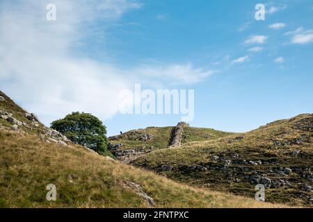 Northumberland UK: Hadriansmauer an einem sonnigen Sommertag in englischer Landschaft auf hohen Klippen (Römische Mauer) errichtet Stockfoto