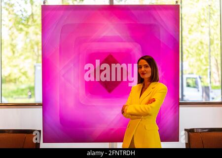 London, Großbritannien. 19 Mai 2021. Die abstrakte Künstlerin Nat Bowen’ posiert mit ihrer Arbeit Pink Diamond', 2021. Vorschau auf „Chromadelic“, die Einzelausstellung von Nat Bowen in der Park Lane 45 in Mayfair. Die Künstlerin nutzt die Studie der Chromologie, der Psychologie hinter Farbe, und nutzt dabei Einflüsse aus den Farben und Formen der 60er und 70er Jahre, um Harz mit hellen Neonfarben pigmentiert gegen seltene natürliche Pigmente zu beschlagen. Das Highlight ist der ‘Pink Diamond’ mit natürlichem Rosenblütenpigment und echtem rosafarbenem Diamantstaub, der in 69 Harzschichten eingegossen ist. Ihre Show läuft bis zum 28. Juni 2021. Kredit: Stephen Chung / Alamy Live Nachrichten Stockfoto