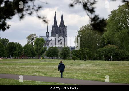 Köln, Deutschland. Mai 2021. Eine Frau geht durch den Rheinpark vor dem Dom. Quelle: Oliver Berg/dpa/Alamy Live News Stockfoto