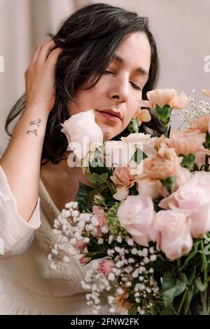 Nahaufnahme Porträt der jungen Frau mit Blumenstrauß und natürlichen Look. Nahaufnahme im Frühling. Ernst und romantischen Ausdruck mit weit geöffneten Augen Stockfoto