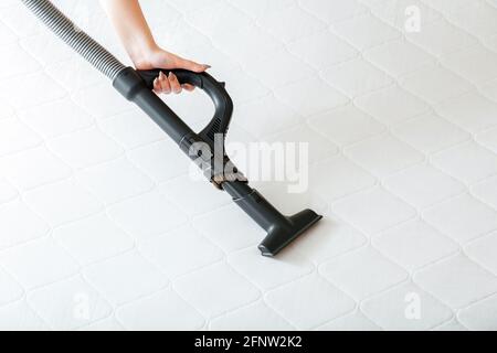 Woman do Professionelle Reinigung Matratze durch Staubsauger von Staub Bakterien schmutzig. Staubsauger Maschine in weiblicher Hand tun Desinfektionsflächen Stockfoto