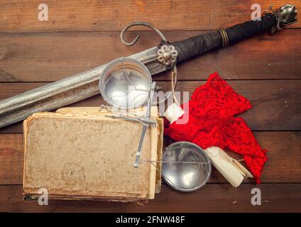 Stillleben mit den legendären Attributen der Gerechtigkeitsskala und dem Schwert der Themis, sowie alte Manuskripte und Gesetzbücher Stockfoto