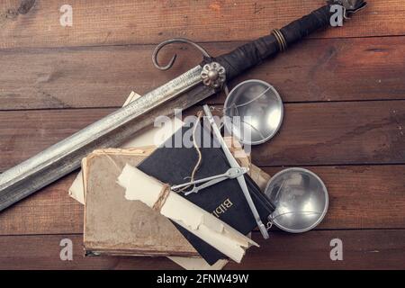 Stillleben mit den legendären Attributen der Gerechtigkeitsskala und dem Schwert von Themis, sowie alte Manuskripte und die Bibel für die Eid Stockfoto